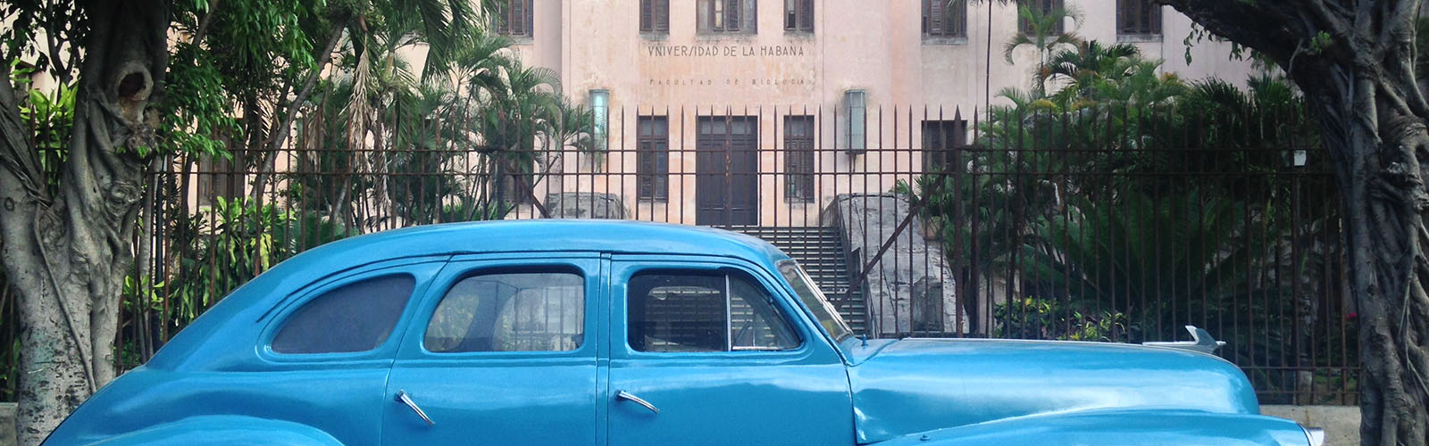 Rustic car parked in front of a building.From 2014