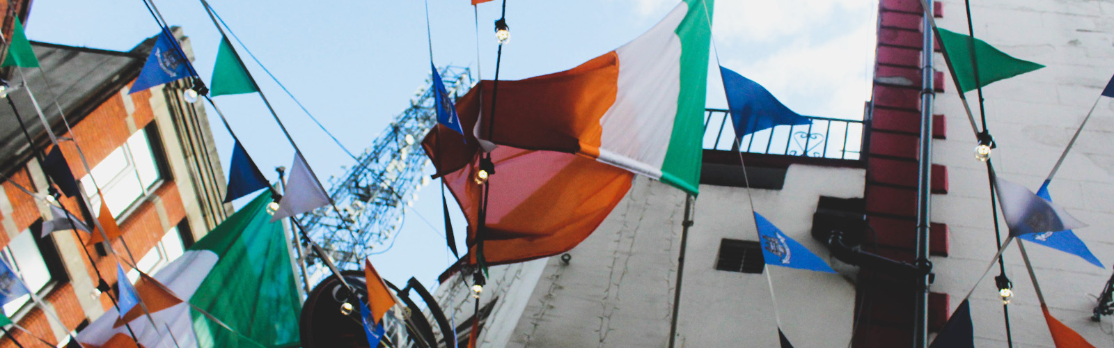 A large Irish flag hangs around several smaller, triangular flags of different colors. 