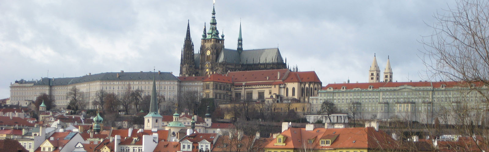 Skyline view of Prague with the main cathedral in the background on a hill.