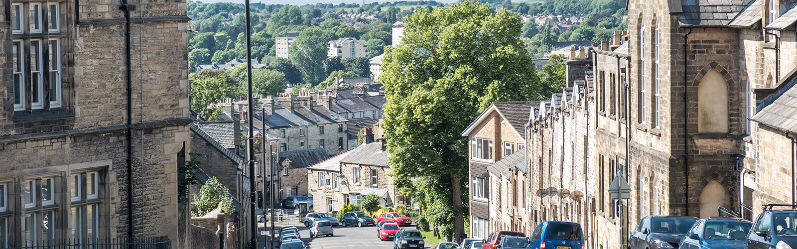 View down a hill in Lancaster. The buildings that line the streets are packed together and have the same old style architecture.