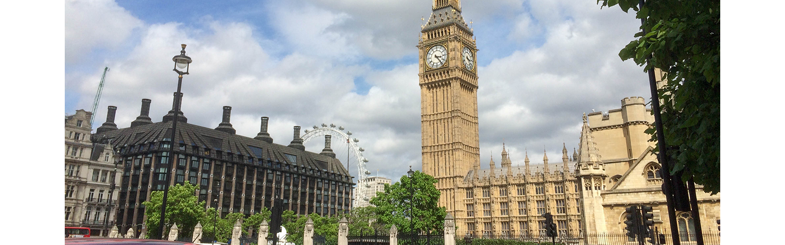 View of Parliament square with Big Ben and the London Eye in the background.