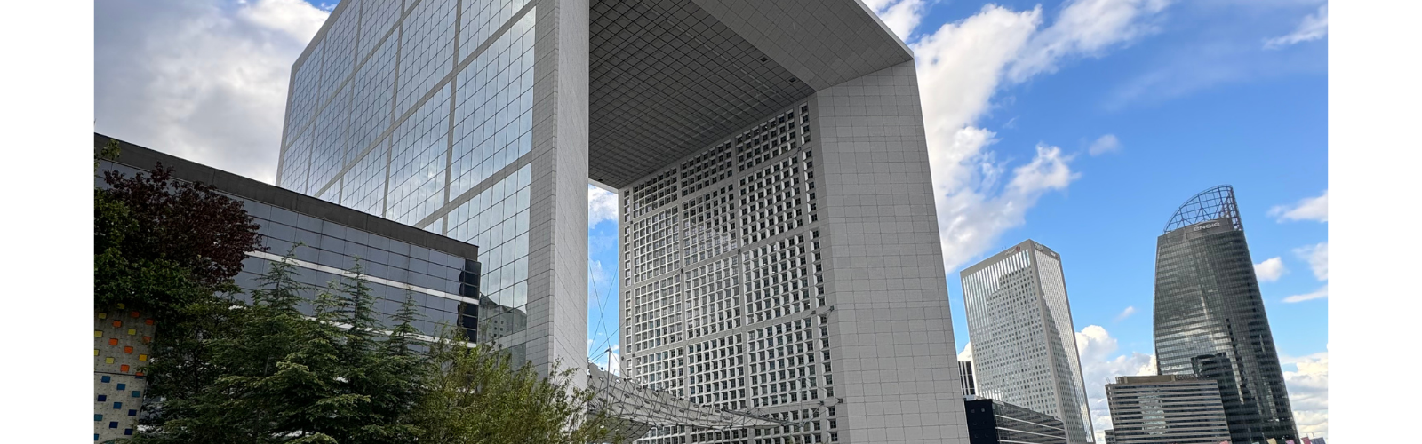 View of a series of buildings in Cergy. All of the buildings are tall and have expansive windows. 