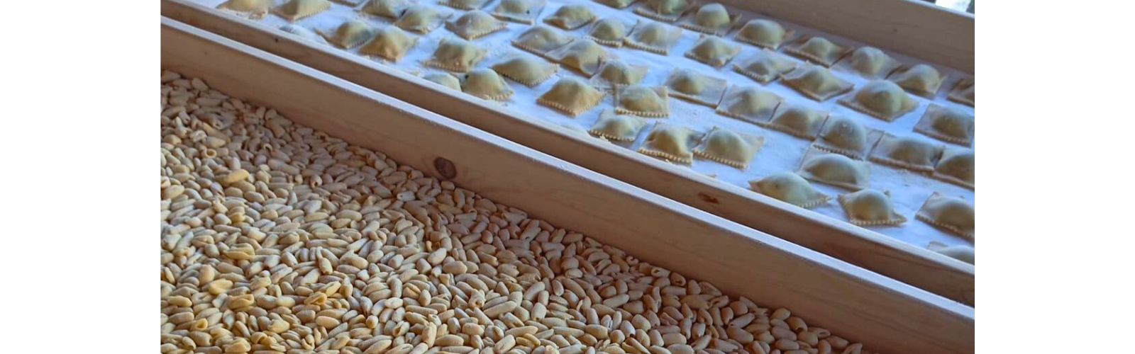 Two wooden containers, with the left filled with grain and the right containing carefully placed ravioli. 