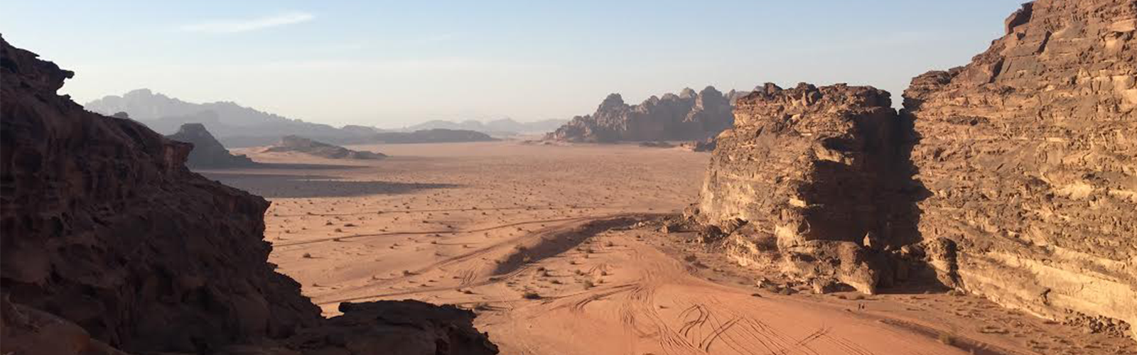 A vast desert with tall, rocky mountains on the left and right. 