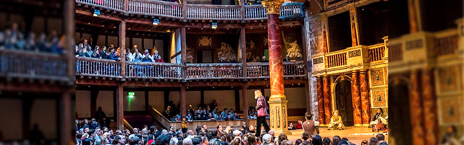 A performer is on stage doing a play at Shakespere's globe. There is a large crowd around them that is cheering for the actor.
