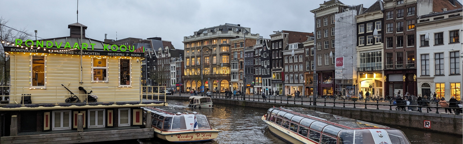 A canal in Amsterdam with boats on the river.